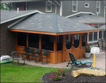 Custom 12 x 14 Cedar Rectangular Gazebo shown with solid bottom railings, 6x6 posts, full set of screens and screen door, customer supplied shingles, 2 coats of cedar stain/sealer, custom double door, 2 overhang, and no back wall (attached to customers house)